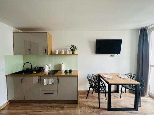 eine kleine Küche mit einem Tisch, einem Tisch und Stühlen in der Unterkunft Mare e Monti Apartments in Kattowitz
