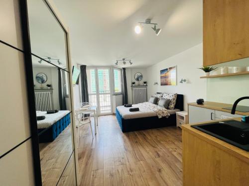 ein Wohnzimmer mit einem Bett und eine Küche in der Unterkunft Mare e Monti Apartments in Kattowitz