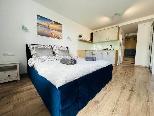 a large blue bed in a room with a kitchen at Mare e Monti Apartments in Katowice