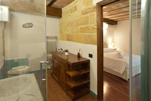 ein Bad mit einer Glasdusche und einem Bett in der Unterkunft BIBI'S HOUSE in Terrasini