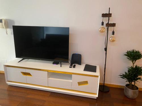 TV de pantalla plana en la parte superior de un armario blanco en Host'In Aveiro Arrais, en Aveiro