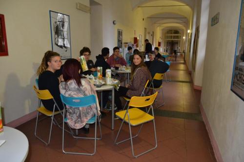 a group of people sitting at tables in a restaurant at Il Chiostro Hostel and Hotel in Alessandria