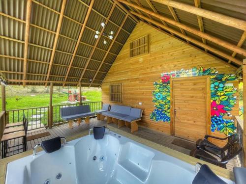 - une chambre avec baignoire dans une maison en bois dans l'établissement Espectacular Cabaña Loft en Guatape - Jacuzzi, à El Peñol