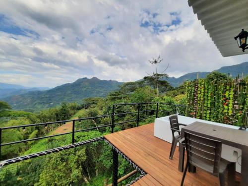 balcón con mesa y vistas a las montañas en Cabañas Bellavista La Vega, en La Vega