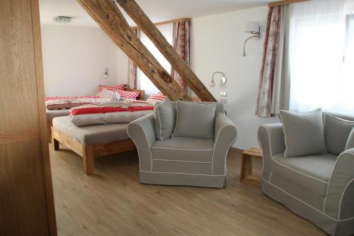 a bedroom with two beds and two chairs at Adam & Eva Gasthof Paradies mit Hotel in Vogt