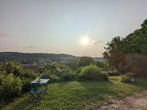 une table sur un champ avec le soleil dans le ciel dans l'établissement Private studio with garden - Maison 1870, à Sarlat-la-Canéda