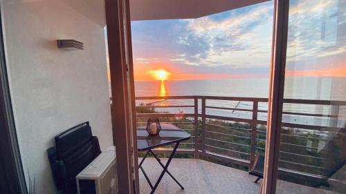 a balcony with a view of the ocean at sunset at Porta Mare - Dziwnówek - Ferienappartment an der polnischen Ostsee in Dziwnówek