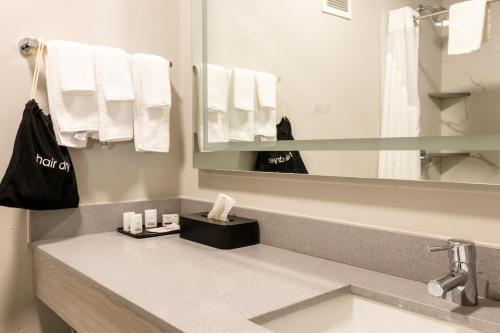 ein Badezimmer mit einem Waschbecken, einem Spiegel und Handtüchern in der Unterkunft Silver Beach Hotel in Saint Joseph