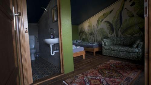 ein Bad mit einem Waschbecken und einem Sofa in einem Zimmer in der Unterkunft Sárgarigó Élményház in Szeged