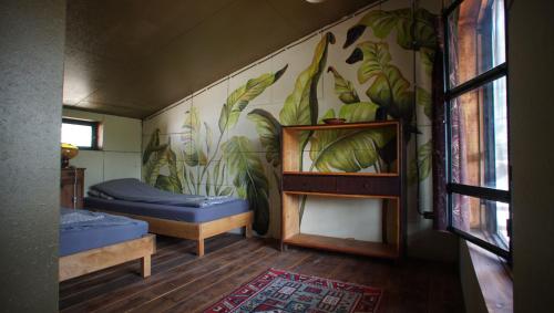 una habitación con 2 camas y una pared con plantas en Sárgarigó Élményház, en Szeged