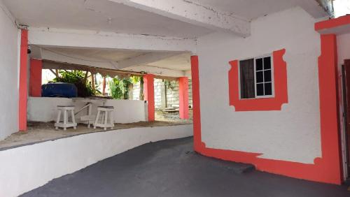 an empty building with red and white walls and stools at Charming 1-Bedroom House in St Thomas Jamaica in Belfast