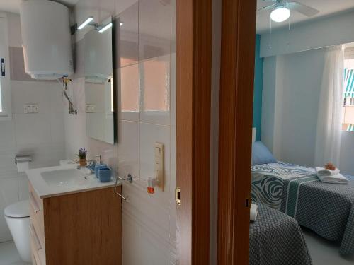 un bagno con lavandino e una camera con letto di Caballito de mar, parking, AC y fibra VT-52619-V a Gandía