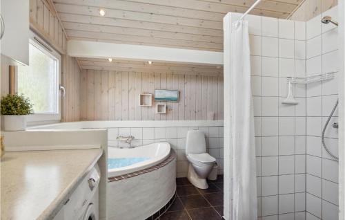 a bathroom with a tub and a toilet and a sink at Gorgeous Home In Hals With Sauna in Hals