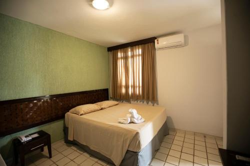 a bedroom with a bed with a stuffed animal on it at Rio Quente Resorts - Eco Chalés in Rio Quente