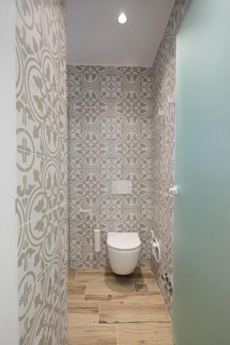 a bathroom with a white toilet in a room at Flora Apartments & Studios in Agia Anna Naxos