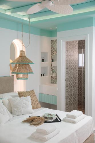 a bedroom with a white bed with a blue ceiling at Flora Apartments & Studios in Agia Anna Naxos