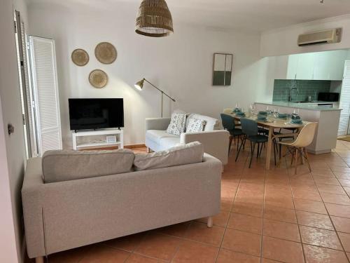 - un salon avec un canapé et une table dans l'établissement Moradia V3 na Praia Verde, à Castro Marim