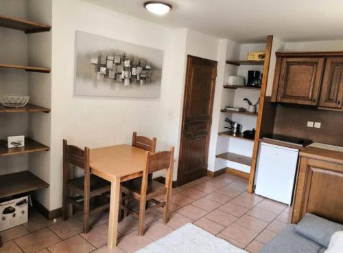 a kitchen with a wooden table and a refrigerator at Orcières Merlette appartement T2 à 50m des pistes-4 personnes-Chalet d’Orcières- été et hiver in Orcières