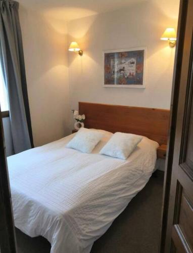 une chambre avec un lit blanc avec deux oreillers dans l'établissement Orcières Merlette appartement T2 à 50m des pistes-4 personnes-Chalet d’Orcières- été et hiver, à Orcières