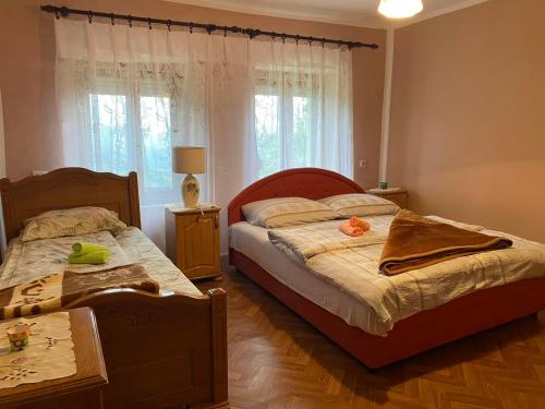 1 dormitorio con 2 camas y ventana en Seosko Domaćinstvo Vulević, en Andrijevica