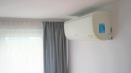 a room with a tv on the wall next to a window at Apartament ENJOY Zator - z widokiem na Energylandie in Zator