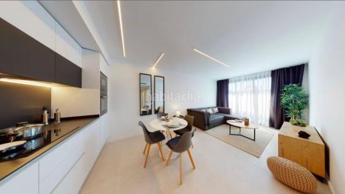 a kitchen and living room with a table and chairs at Kobé Place in Barcelona