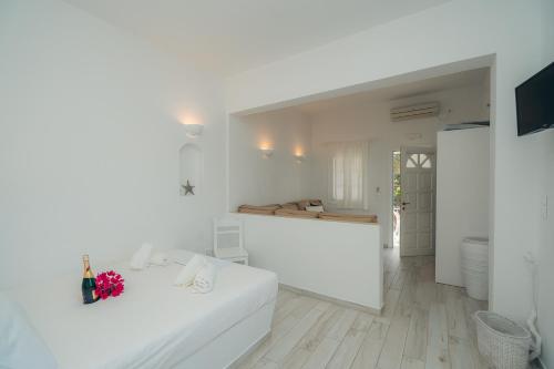 a white room with a bed and a kitchen at Nostos Sifnos in Apollonia