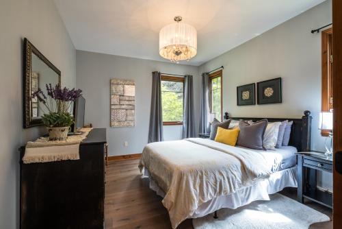 um quarto com uma cama grande e um lustre em Tremblant Prestige-Altitude 170-1 em Mont-Tremblant