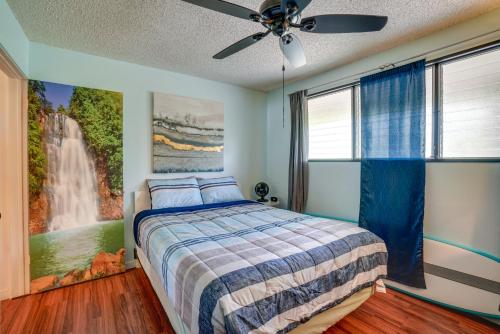 a bedroom with a bed and a waterfall painting on the wall at Molokai Island Retreat with Ocean View and Pool! in Kaunakakai