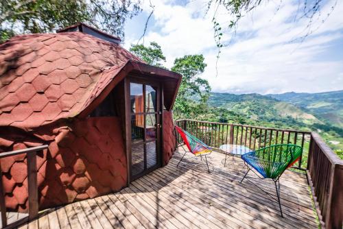 a deck with two chairs on top of a building at Tambo Eco Hotel in La Vega