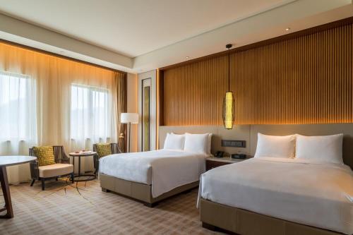 a hotel room with two beds and a desk at JW Marriott Hotel Zhejiang Anji in Anji