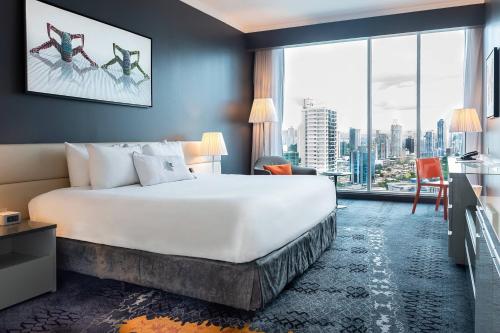 パナマシティにあるSortis Hotel, Spa & Casino, Autograph Collectionのベッドと大きな窓が備わるホテルルームです。