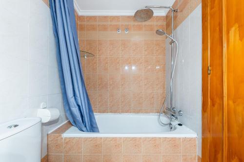 uma casa de banho com um chuveiro, uma banheira e um WC. em Apartamento con piscina Los Altos em Torrevieja