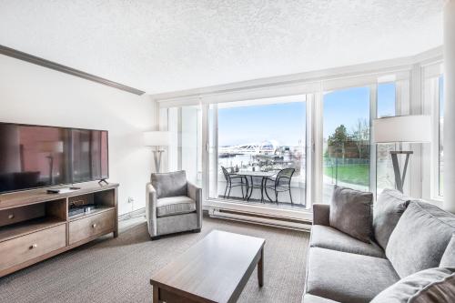 un soggiorno con divano e una grande finestra di Victoria Regent Waterfront Hotel & Suites a Victoria