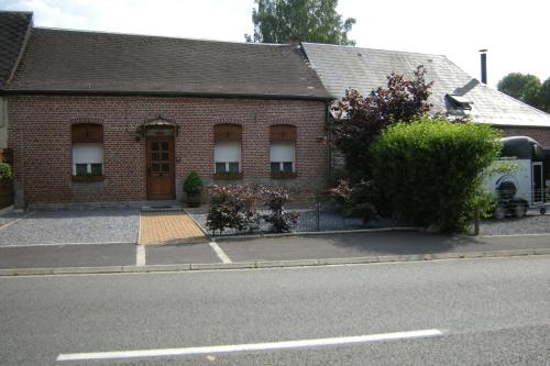 a brick building with a door on a street at Gîte Onze in Liessies