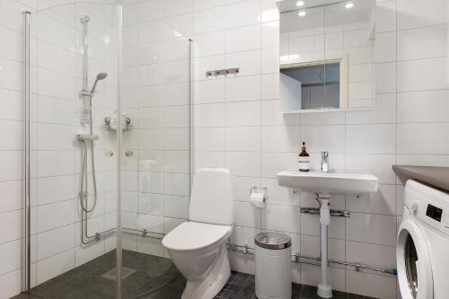 a bathroom with a toilet and a sink and a shower at Guestly Homes - 3BR Modern Apartment in Piteå