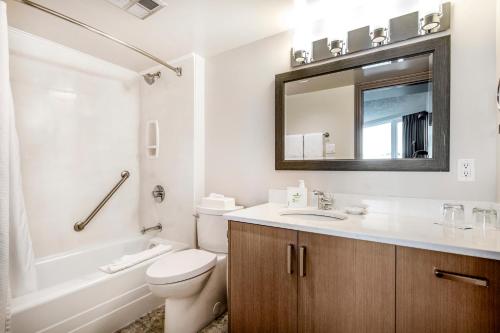 a bathroom with a sink and a toilet and a mirror at Victoria Regent Waterfront Hotel & Suites in Victoria