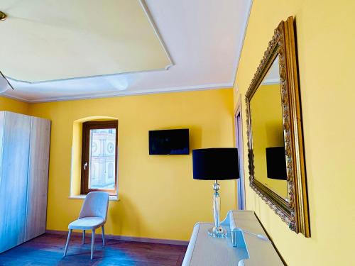 a yellow room with a mirror and a table and chair at B&B L’Orizzonte Infinito in Chiaromonte