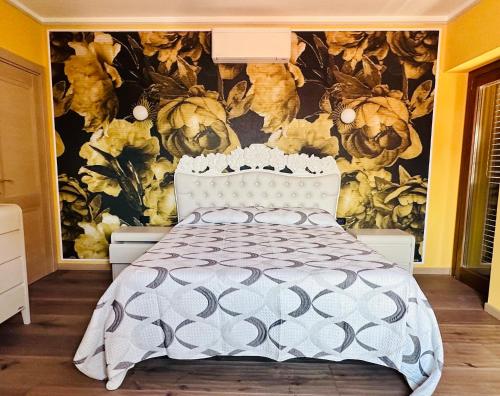a bedroom with a bed with a floral wallpaper at B&B L’Orizzonte Infinito in Chiaromonte