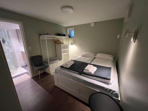 ein kleines Schlafzimmer mit einem Bett und einem Stuhl in der Unterkunft Great place with view to the mountains and fjord in Ålesund