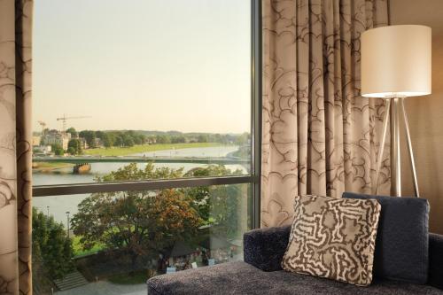 a room with a large window looking out at a river at Sheraton Grand Krakow in Kraków