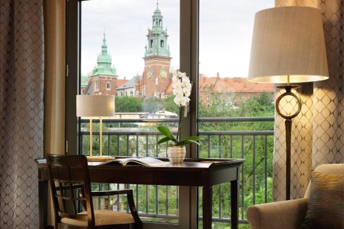 a desk with a window with a view of a building at Sheraton Grand Krakow in Kraków