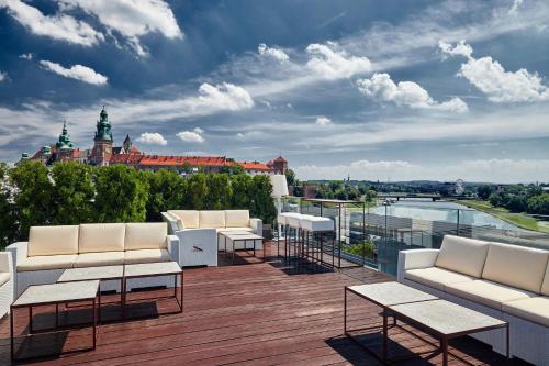 a balcony with white furniture and a view of a city at Sheraton Grand Krakow in Krakow