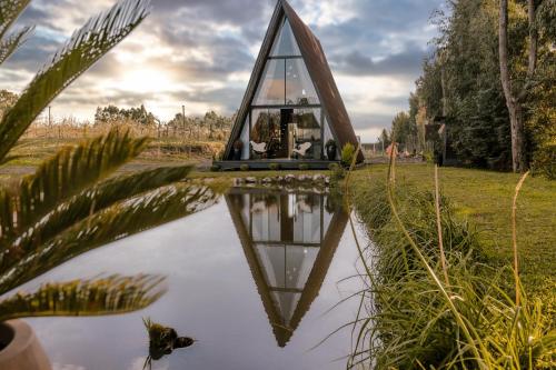 uma pequena casa de vidro no meio de um lago em Chalé Alqualondë -Chácara Valfenda em São Joaquim