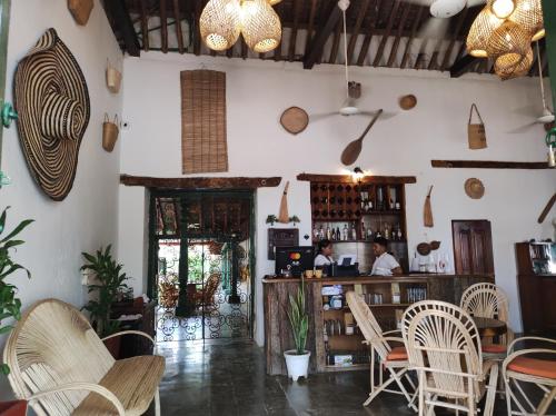 un restaurante con sillas y un bar con 2 personas. en HOTEL NIETO MOMPOX, ubicado en el corazón del centro histórico, frente al rio magdalena en zona de malecón en Mompox