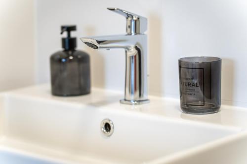 a bathroom sink with a soap dispenser and a faucet at Capsula Luxury Apartment Umag in Umag