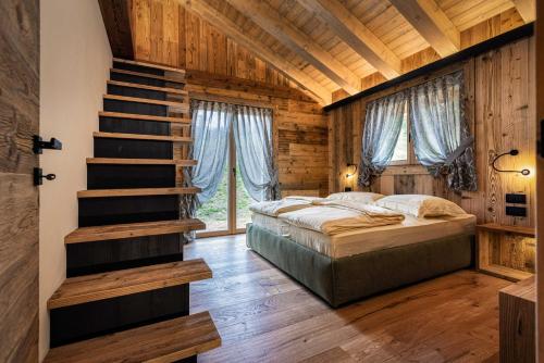 - une chambre avec un lit et un plafond en bois dans l'établissement Rifugio de Dòo, à San Nicolò di Comelico