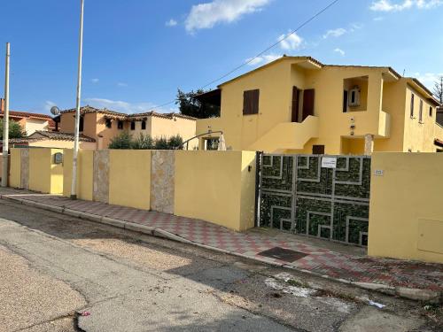 a yellow fence in front of a house at Villaluciana Solanas in Solanas