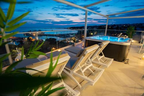 een balkon met stoelen en een hot tub op het dak bij Bed&Breakfast Novalis in Novalja