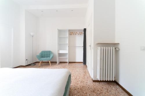 - une chambre avec un lit et une chaise bleue dans l'établissement Spacious Apartment - 4 Bedrooms and 3 Bathrooms, à Bergame
